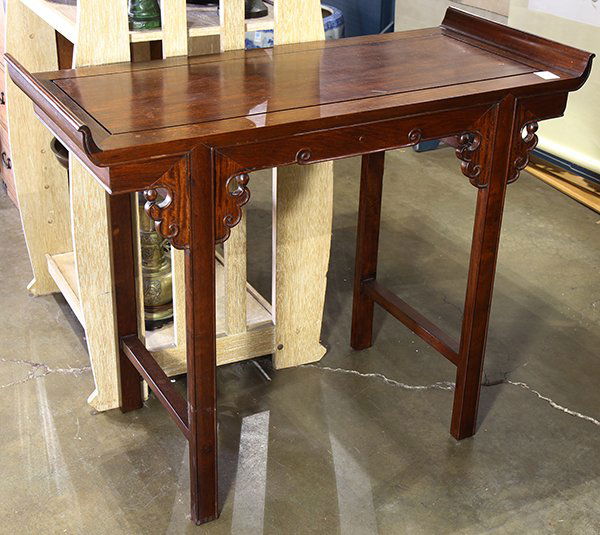 Chinese Wooden Side Table: Chinese hardwood side table, with upturned flanges flanking the top inset with a floating panel, the apron carved with scrolls and bracketed by ruyi spandrels, raised on straight bead edge supports, 3