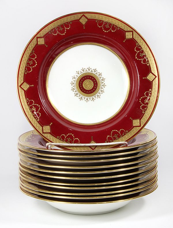 Twelve Minton soup plates: Twelve Minton soup plates, each having a gilt rim, accented with scrolled and beaded designs continuing to the claret ground center a cream ground surrounding a rosette medallion, each 10"dia. Provena