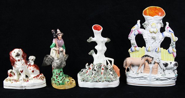 (lot of 4) English Staffordshire figural groups,: (lot of 4) English Staffordshire figural groups, including a whimsical witch carrying a broomstick and riding a bird; a spaniel in russet red with two pups; together with two spill vases, one depictin