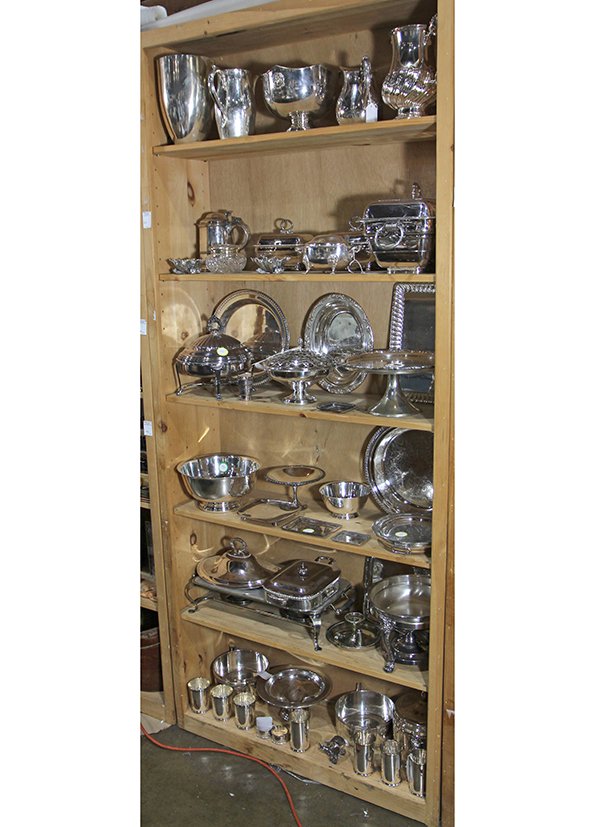 Six shelves of associated silver plate table: Six shelves of associated silver plate table accessories, including (3) water pitchers, a pair of shell form bon-bons, (9) covered and open warm serving pieces, a footed cake stand, (2) Paul Revere st
