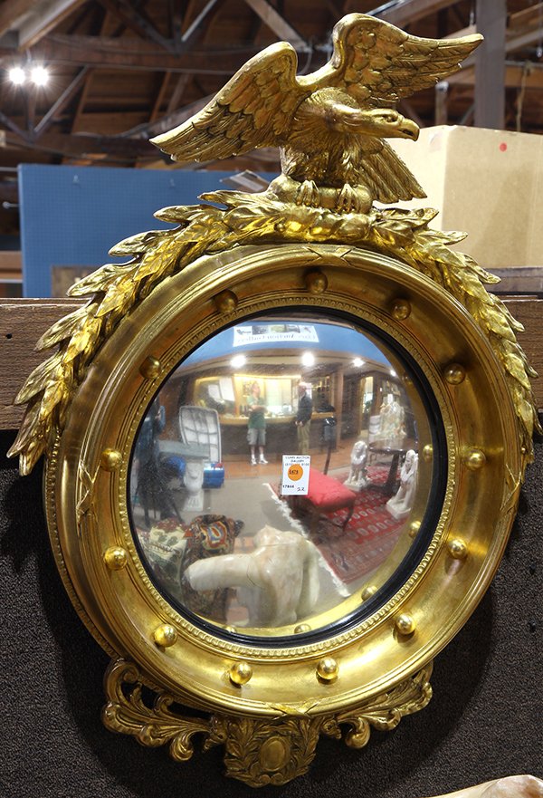 Federal convex looking glass, the giltwood form: Federal convex looking glass, the giltwood form surmounted with a bald eagle, depicted clutching garland, the looking glass accented with spherical reserves and terminating with a drop medallion, 35"h