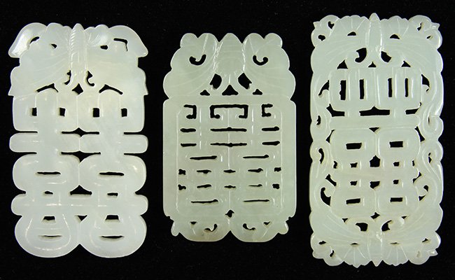 Three Chinese Jade, Shuangxi Butterflies: (lot of 3) Chinese jade plaques, each of a pale white-celadon hue pierced with the shuangxi emblem accented by butterflies, largest: 3.25"h. Provenance: collection of Mrs. Ellen Sutton, Incline Villag