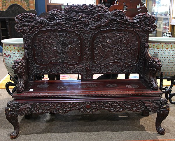 Japanese Dragon Carved Settee, Meiji: Japanese wooden settee, Meiji period, of a reddish dark brown color, the back carved with a dragon above two phoenix with inlaid eyes, raised on dragon shaped supports and arm rests each with a jewel 