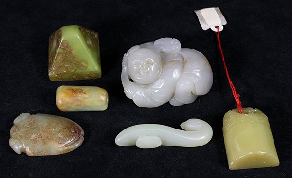 Six Chinese Stone/Jade Carvings: (lot of 6) Chinese stone carvings, consisting of a soapstone seal of pyramid form; another with a gateway above rolling waves; along with a jade/hardstone small belt hook; a cylindrical bead; a cicada