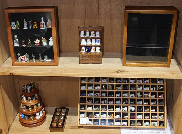 Thimble collection: (lot of approx 165) Thimble collection in display cases and stand executed in procelain, glass, brass, ceramic, and mixed metal examples including floral themes, holiday themes, and international them