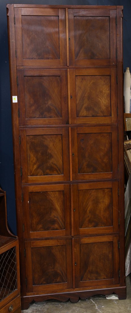 Victorian cabinet: Victorian cabinet, executed in mahogany, having five pairs of paneled door, each with an escutcheon and each opening to an interior shelf and drawer with flush mount brass hardware, the whole resting 