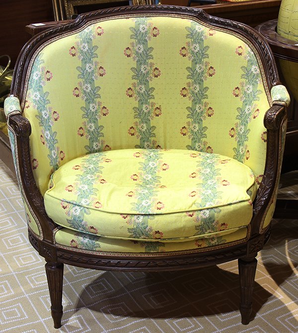 Louis XV style bergere, executed in walnut, having a: Louis XV style bergere, executed in walnut, having a shaped crest above the seat and back upholstered in yellow silk brocade and rising on fluted and tapered legs, 34"h x 32"w x 19.5"d. Provenance: Fr