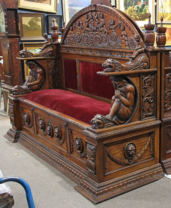 Continental Renaissance style hall bench: Continental Renaissance style hall bench, having a carved superstructure decorated with putti in an ocean landscape, above the velvet upholstered seat and back, flanked with lion and figural supports,