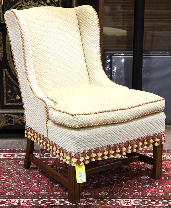Moderne upholstered slipper chair, having a winged: Moderne upholstered slipper chair, having a winged back, upholstered in checkered white, with yellow and red fringe, and rising on square legs, 33"h x 23"w x 19"d. Provenance: From the Ligonier, PA es