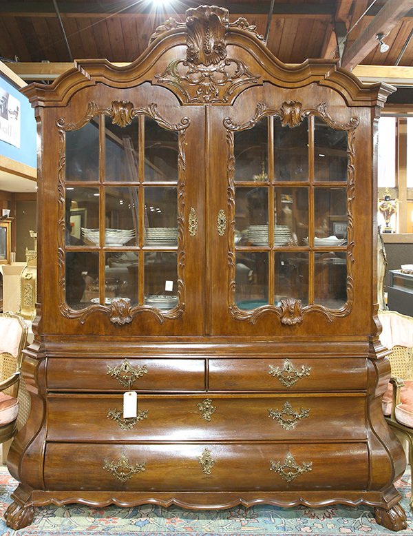 Dutch Rococo style bombe vitrine, circa 1860, the: Dutch Rococo style bombe vitrine, circa 1860, the superstructure having a molded cornice centered with a relief carved crest having floral accents, above a scroll and acanthus decorated medallion, con