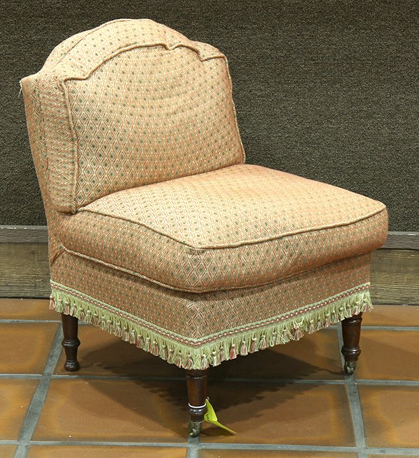 Moderne slipper chair, having an orange upholstered: Moderne slipper chair, having an orange upholstered seat and back accented with green polka dots, and rising on tapered legs terminating on casters, 26"h x 21"w x 18"d. Provenance: From the Ligonier, 