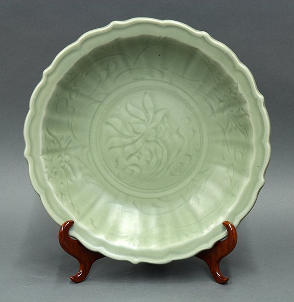 Chinese Longquan Celadon Charger: Chinese Longquan celadon glazed charger, Ming dynasty, the interior and exterior incised with flowers and tendrils, the everted rim with a foliate edge (repaired), 13.75"w; Provenance: from the collec