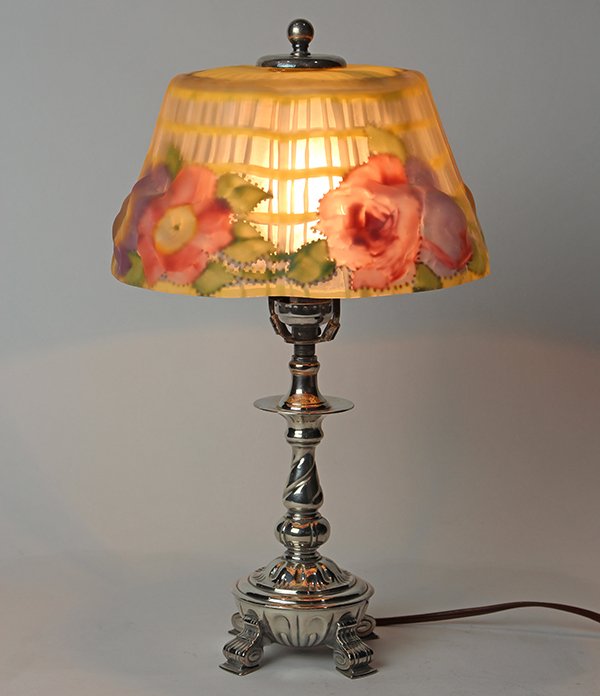 Pairpoint puffy boudoir table lamp, the draping shade: Pairpoint puffy boudoir table lamp, the draping shade with reverse painted flower decoration, above a baluster form silver plate standard, rising on outswept feet, 15"h. Provenance: Property from the
