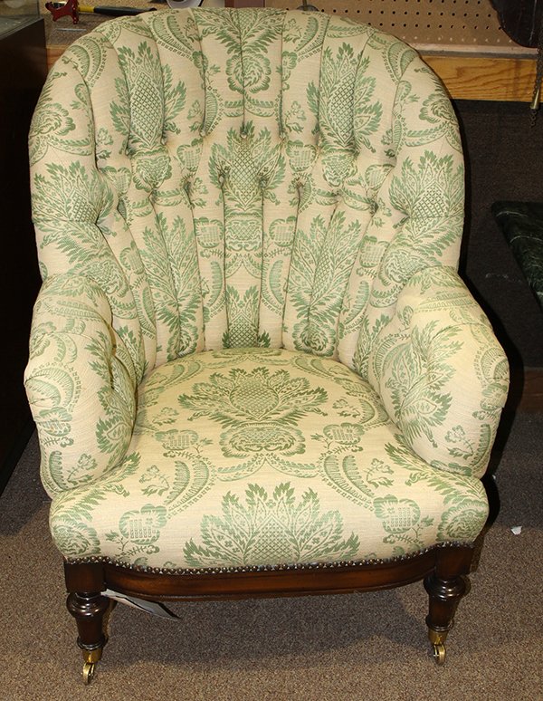 Pair of Moderne upholstered armchairs: Pair of Moderne upholstered armchairs, each having a tufted back, covered in green and white woven damask, the base accented with brass nail head trim, and rising on turned legs, terminating on caster