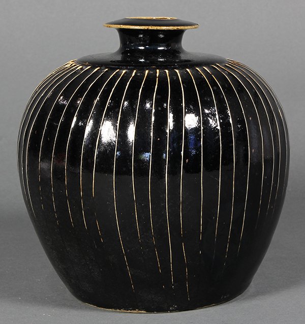 Chinese Black Glaze Jar: Chinese black glazed ceramic jar, with an everted rim and short neck, above a stylized melon form body, the dark glaze thinning white at the vertical ribs, 7"h