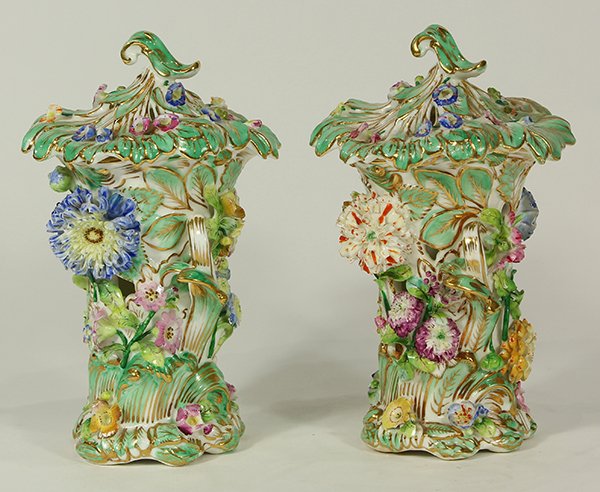 Pair of English porcelain flower-encrusted lidded vases: Pair of English porcelain flower-encrusted lidded vases, circa 1830, possibly Minton or Coalbrookdale, each modeled as stylized plants with applied polychrome decorated floral sprays, and rising on a 