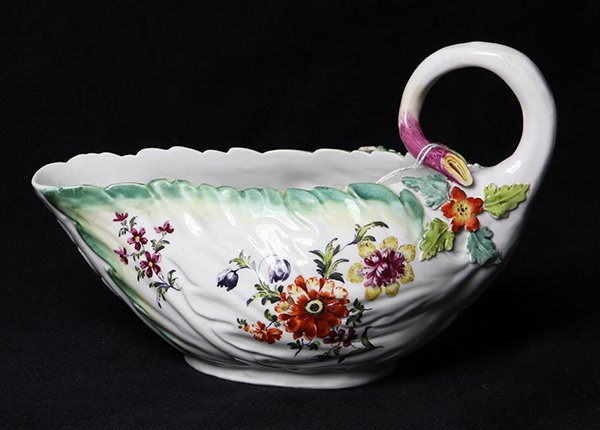 Early Derby sauce boat, having a: Early Derby sauce boat, 18th century, having a naturalistic twig handle with applied flowers and leaves on a body with a shaped rim and scattered hand painted floral sprays, 4.5"h x 7"l x 3.5"d