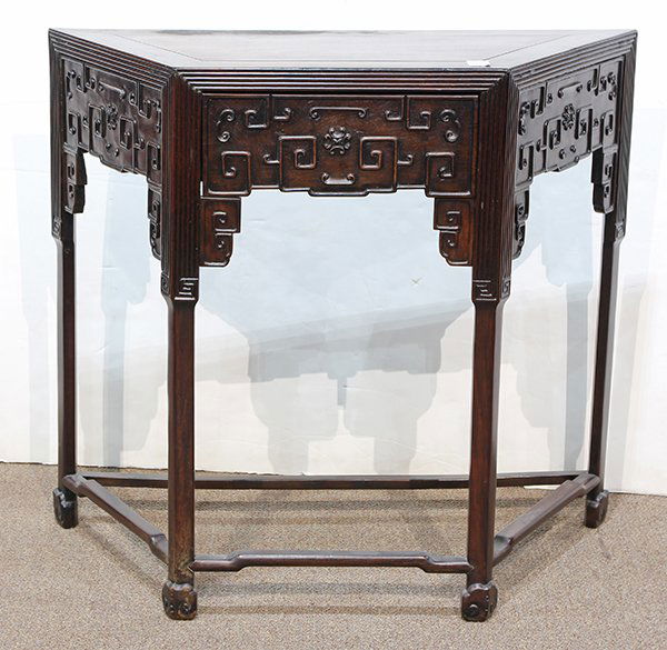 Chinese Wooden Trapezoidal Side Table: Chinese hardwood trapezoidal side table, the top with a single floating panel of conforming shape, the short side fronted with a drawer in the same pattern as the apron, carved with scrolls in relief