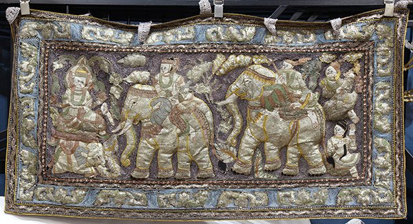 Burmese kalaga wall hanging: Burmese kalaga wall hanging, decorated with polychrome scrolled beadwork centering a scene with riders on horseback, 30"h x 57"w