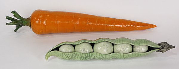 Sculptures by Karen Shapiro: (lot of 2) Karen Shapiro (American, b. 1947), Giant Carrot and Pea Pod, ceramic sculptures, stamped "K" on bottom, largest overall: 5"h x 28.5"w x 5"d.
