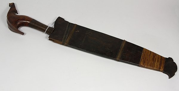 Indonesian style kris, having a carved handle, above: Indonesian style kris, having a carved handle, above the blade in a sheath, 24.5"l