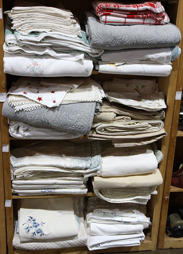 Four shelves of assorted bed and table linens (1 of 2)