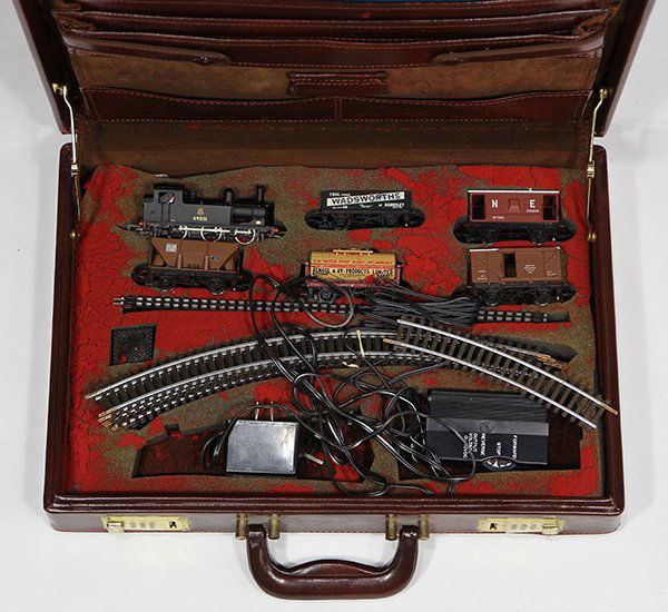 (lot of 20) Mainline OO gauge toy train set, comprising: (lot of 20) Mainline OO gauge toy train set, comprising a JL2 locomotive #69001, (5) cars, straight and curved track, and a transformer, in a fitted leather briefcase. Provenance: From the Ligonier, P
