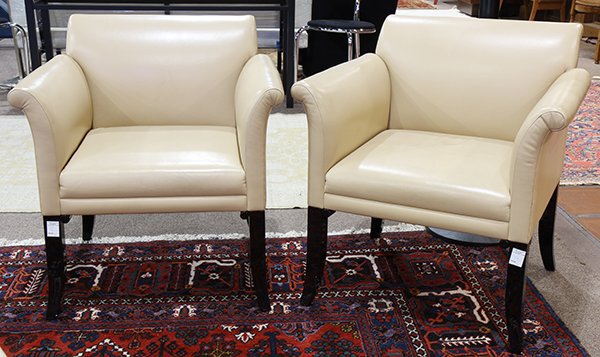 Pair of Art Deco style club chairs: Pair of Art Deco style club chairs, each having a leather seat and back with outswept arms and rising on black laquer legs terminating on outswept feet, 30"h x 29"w x 23"d