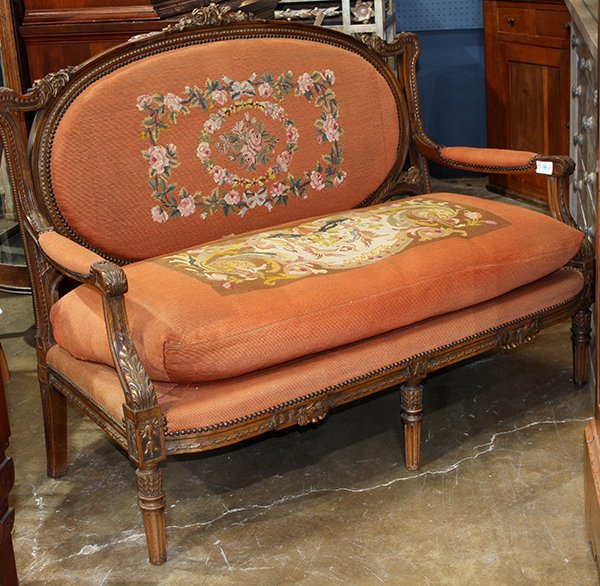 Louis XV style settee, having a floral carved crest,: Louis XV style settee, having a floral carved crest, above the needlepoint seat and back, accented with brass nail head trim, and rising on fluted and tapered legs, 40"h x 51"w x 22"d. Provenance: Pro