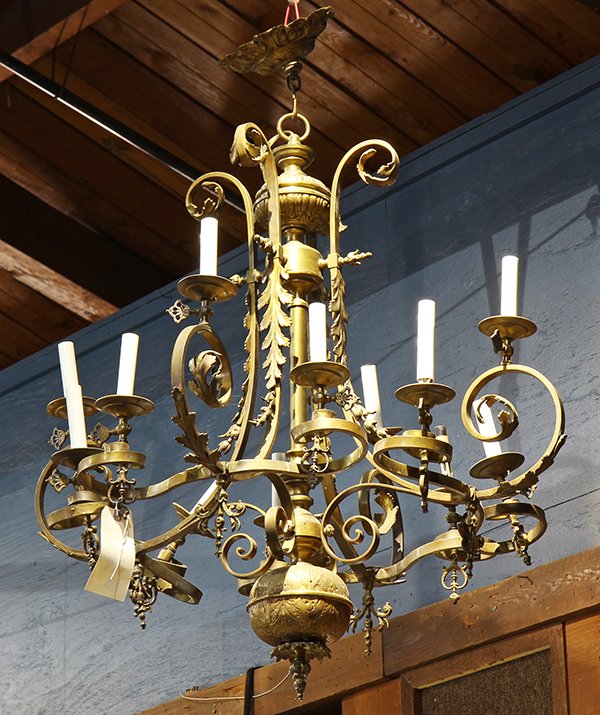 Gothic style patinated bronze chandelier: Gothic style patinated bronze chandelier, the tiered twelve light fixture having having scroll supports accented with acanthus mounts, and terminating at the spherical drop, 38"h x 28"w