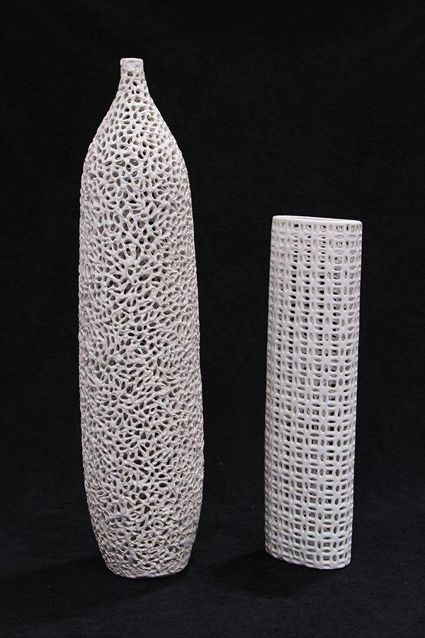 (lot of 2) Large Moderne stoneware vases: (lot of 2) Large Moderne stoneware vases, each executed in white and having a pierced cutwork lace pattern, one having a stick neck, largest: 30.5"h
