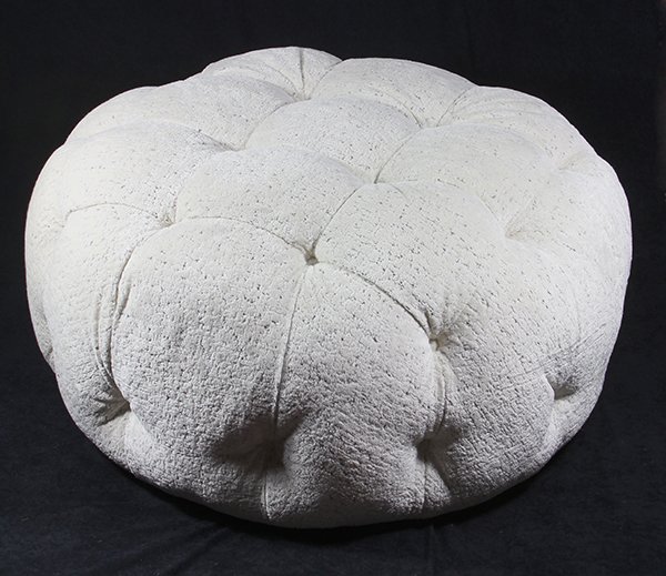 Moderne white upholstered tufted ottoman, having a: Moderne white upholstered tufted ottoman, having a circular form with upholstery having silvered accents, 19"h x 34"dia.