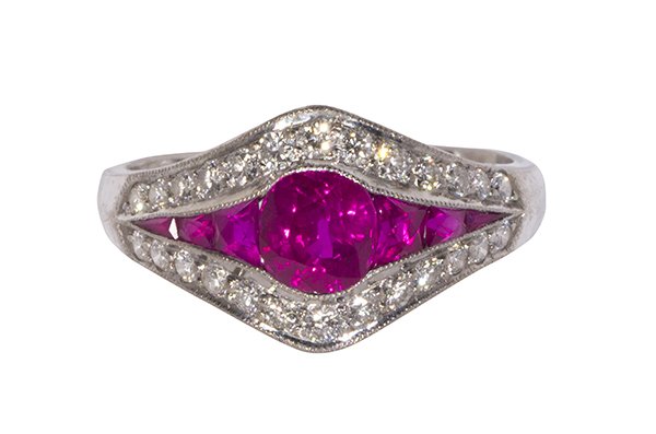 Ruby, diamond and 18k white gold ring: Ruby, diamond and 18k white gold ring featuring (1) round cut ruby weighing approximately 0.85 ct., flanked by (6) calibre-cut rubies weighing a total of approximately 0.30 ct., accented by (26) full