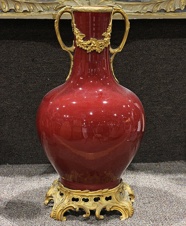 Continental ormolu mounted oxblood vase: Continental ormolu mounted oxblood vase, the shouldered form having a handled mount continuing to the shoulder, and rising on a gilt bronze footed base, 21"h x 12"w