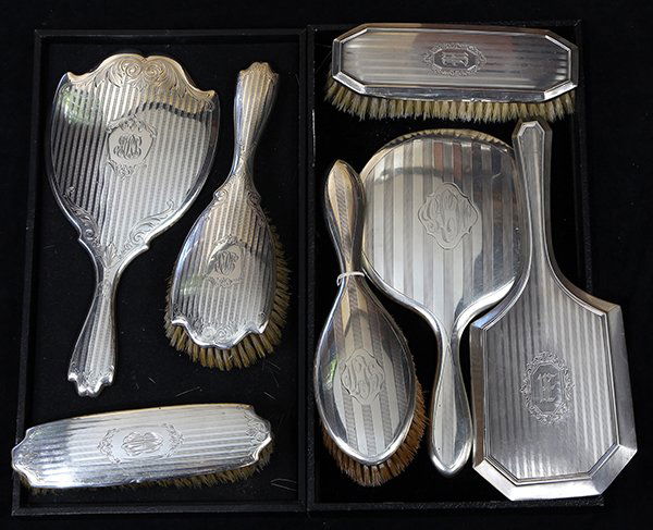 American sterling silver dresser sets by Wallace and: (lot of 7) American sterling silver dresser sets, each having vertical hammering, and centered with monogram reserves, consisting of a shaped hand mirror, hair brush, garment brush, rounded hand mirro
