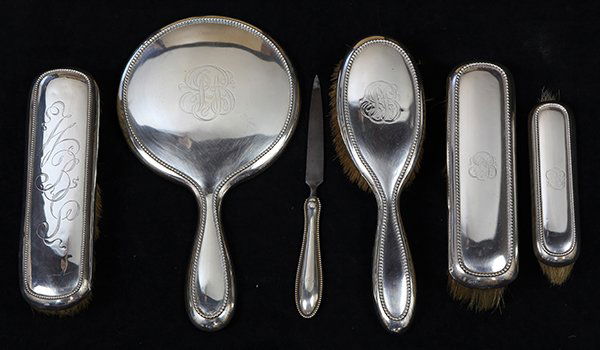 American sterling silver mounted dresser set by Gorham: (lot of 6) American sterling silver mounted dresser set by Gorham and Wallace consisting of a hand mirror, hair brush, garment brushes, and nail file, each polished surface accented with beading enclo