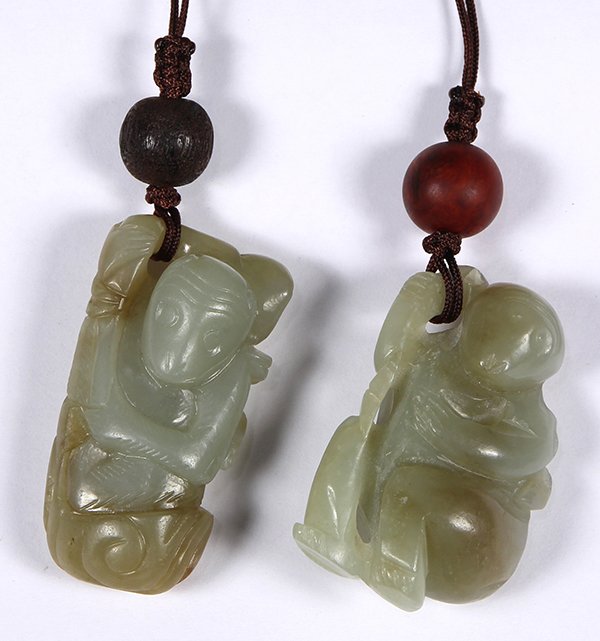 Two Chinese Jade Monkey Form Toggles: (lot of 2) Chinese jade toggles, each carved with a monkey holding a sprig with a peach, 2"h