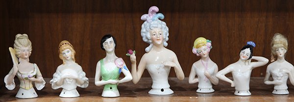 (lot of 17) One shelf of vintage pin cushion doll: (lot of 17) One shelf of vintage pin cushion doll torsos, including examples dressed in the clothing styles of the 18th, 19th, and early 20th centuries, tallest 5.5"h