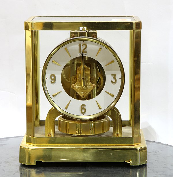 Jaeger LeCoultre Atmos clock, having a brass and glass: Jaeger LeCoultre Atmos clock, having a brass and glass paneled case, the circular dial with triangular stick marks, and rising on a footed base, 9"h x 7.25"w x 5"d. Provenance: Property from the Chris