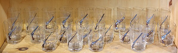 (Lot of 22) Suite of barware, illustrated with: (Lot of 22) Suite of barware, illustrated with historical American fire arms, each with a polychrome rendering of the weapon and an enamel written description of weapons uses and specifications, large