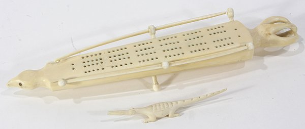 Alaskan Inuit bone cribbage board: Alaskan Inuit bone cribbage board, indigenously carved, decorated with a figure of a bird; together with an indigenously carved smaller figurine of a reptile, largest: 13"l