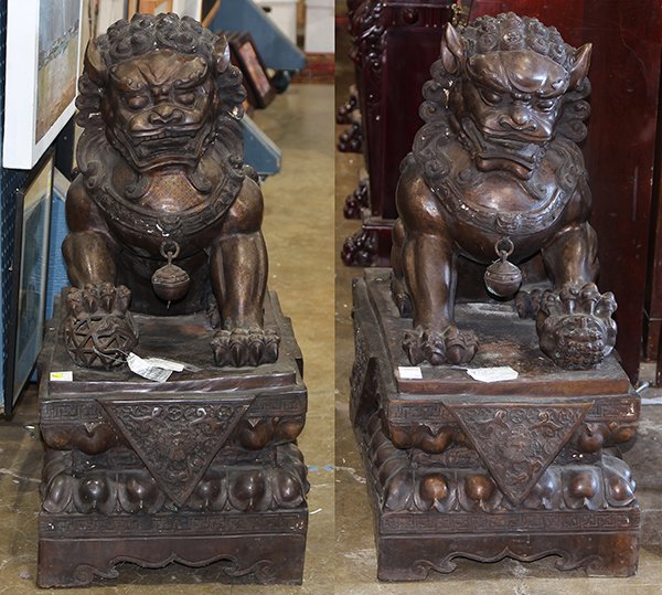 Pair of Chinese patinated bronze Fu-lions: Pair of Chinese patinated bronze Fu-lions, each seated, one with its forepaw resting on a brocade ball, each rising on a square plinth, 32"h