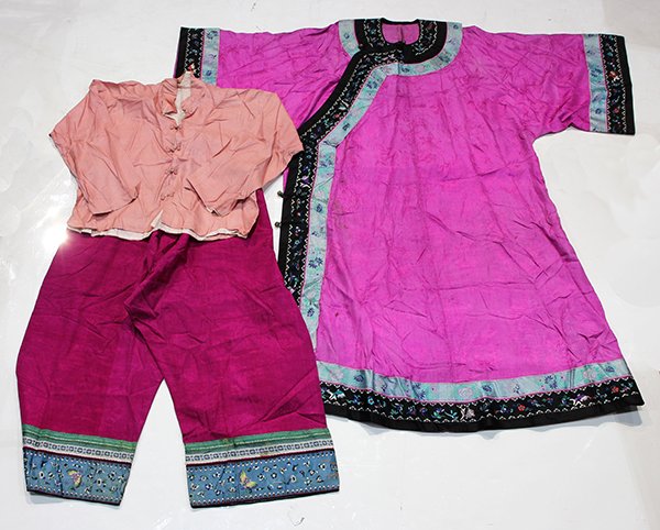 Chinese Pink Robes and Trousers: (lot of 3) Group of Chinese pink ground garments, consisting of a pair of trousers with a damask ground woven with treasures, the bottom with ribbons and blue band with butterflies; one pale pink plai