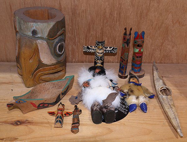 (lot of 10) Native American decorative objects: (lot of 10) Native American decorative objects including Northwest Coast items, consisting of miniature totem poles, a painted canoe, Eskimo items including dolls and a kayak, largest: 6"h