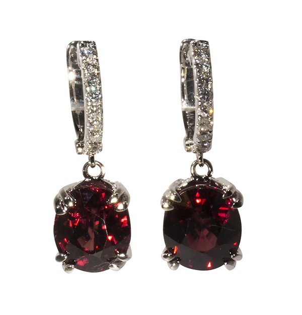 Pair of zircon, diamond and 14k white gold earrings: Pair of zircon, diamond and 14k white gold earrings featuring (2) oval cut deep violet-red zircons weighing a total of approximately 11.21 cts., accented by (18) full cut diamonds weighing a total of 