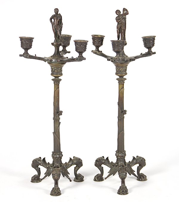 Pair of Gothic Revival three arm candelabra: Pair of Gothic Revival three arm candelabra, each having a figural reserve centering the three arms, and rising on a tripod base terminating on paw feet, 18"h