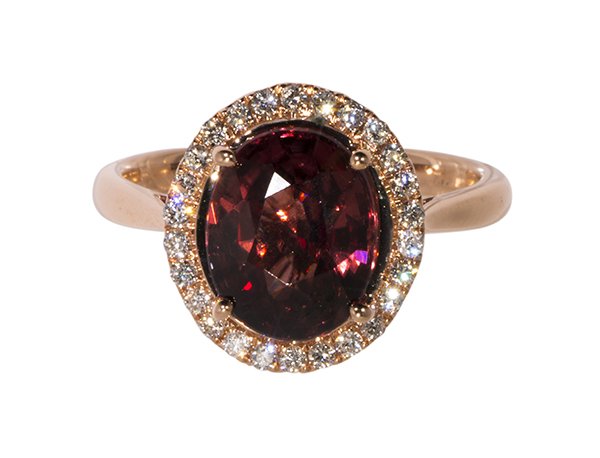 Zircon, diamond and 14k rose gold ring: Zircon, diamond and 14k rose gold ring centering (1) oval cut raspberry zircon weighing approximately 4.52 cts., surrounded by (27) full cut diamonds weighing a total of approximately 0.28 ct., set in