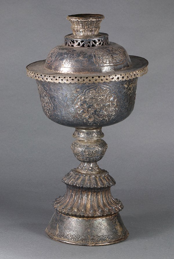 Himalayan Repousse Pedestal Bowl: Himalayan repousse silver pedestal bowl, the domed lid with floral reserves, the bowl with Buddhist Treasures in reserves amid scrolling tendrils, raised on a tiered pedestal base, overall: 16.5"h. Pr