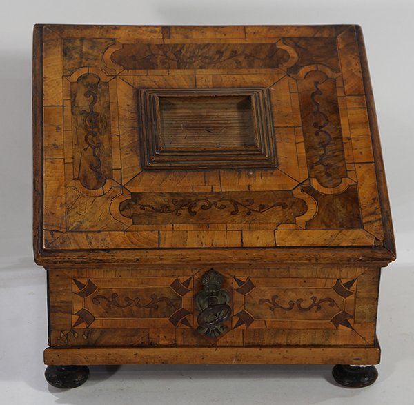 Inlaid jewelry box: Inlaid jewelry box, having a slanted lid with scrolled accents, opening to a fitted interior, the case having a locking mechanism and rising on bun feet, 8.5"h x 10.5"w x 9"d
