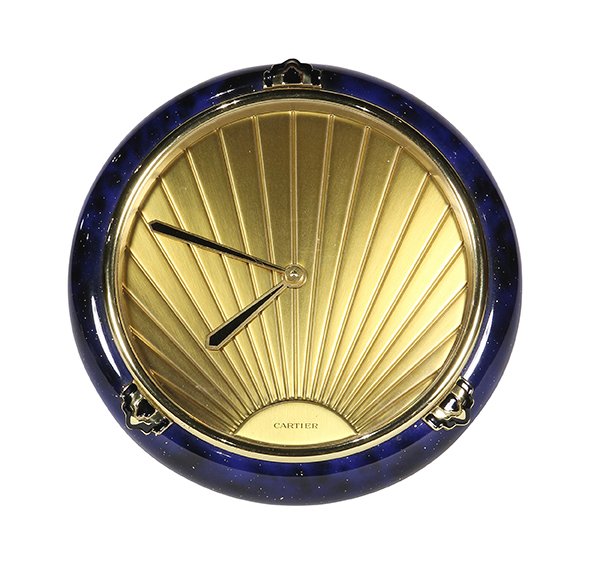 Cartier "Must de Cartier" lacquered and brass desk: Cartier "Must de Cartier" lacquered and brass desk clock. having a starburst face signed Cartier, surrounded by the laquered blue border, 5"h. Provenance: Property from the estate of Thomas J. Perkins